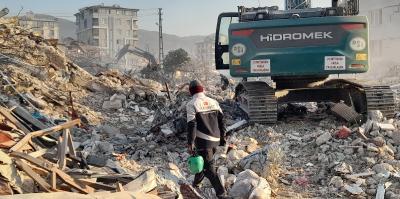 An expert observes the remains of a building in Antakya.