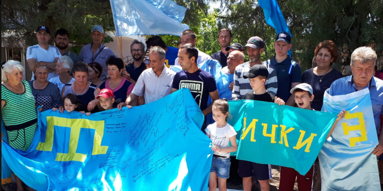 A protest against Russian occupation of Crimea. Protesters carry Crimean Tatar flags.